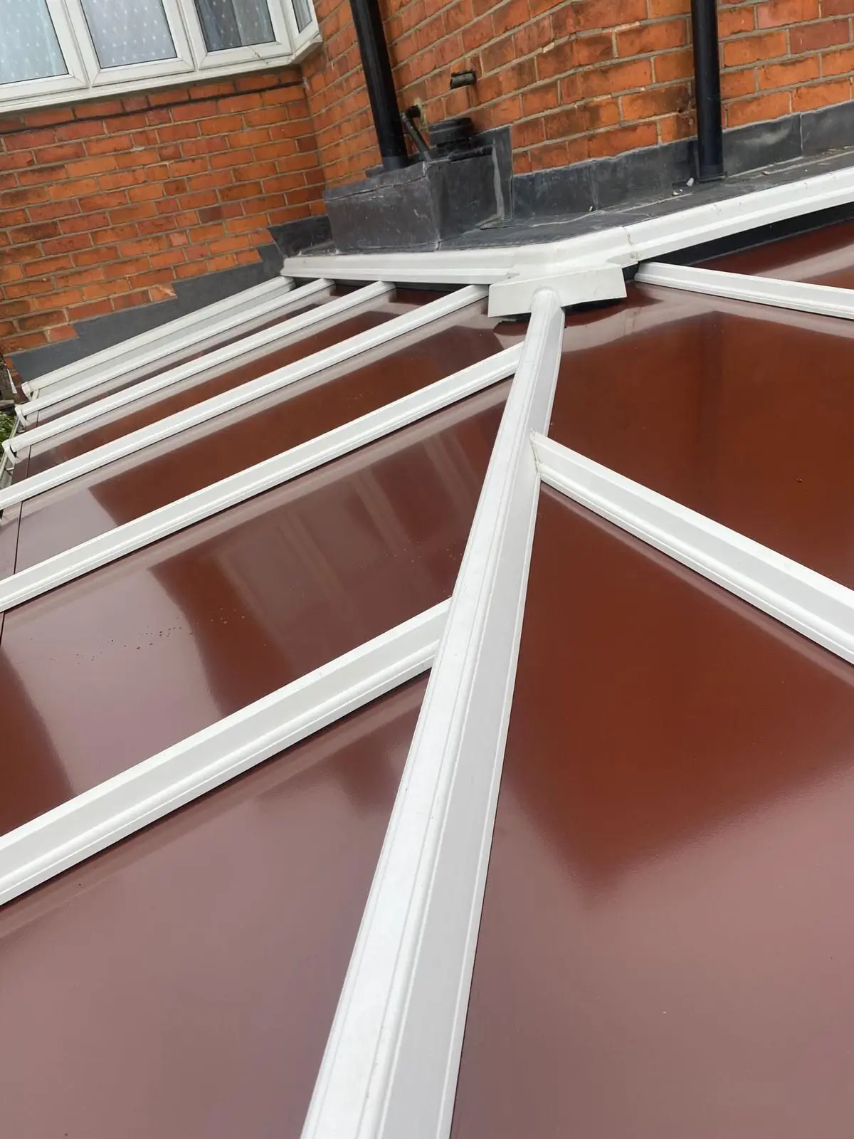 Close view of white glazing bars across a brown insulated conservatory roof