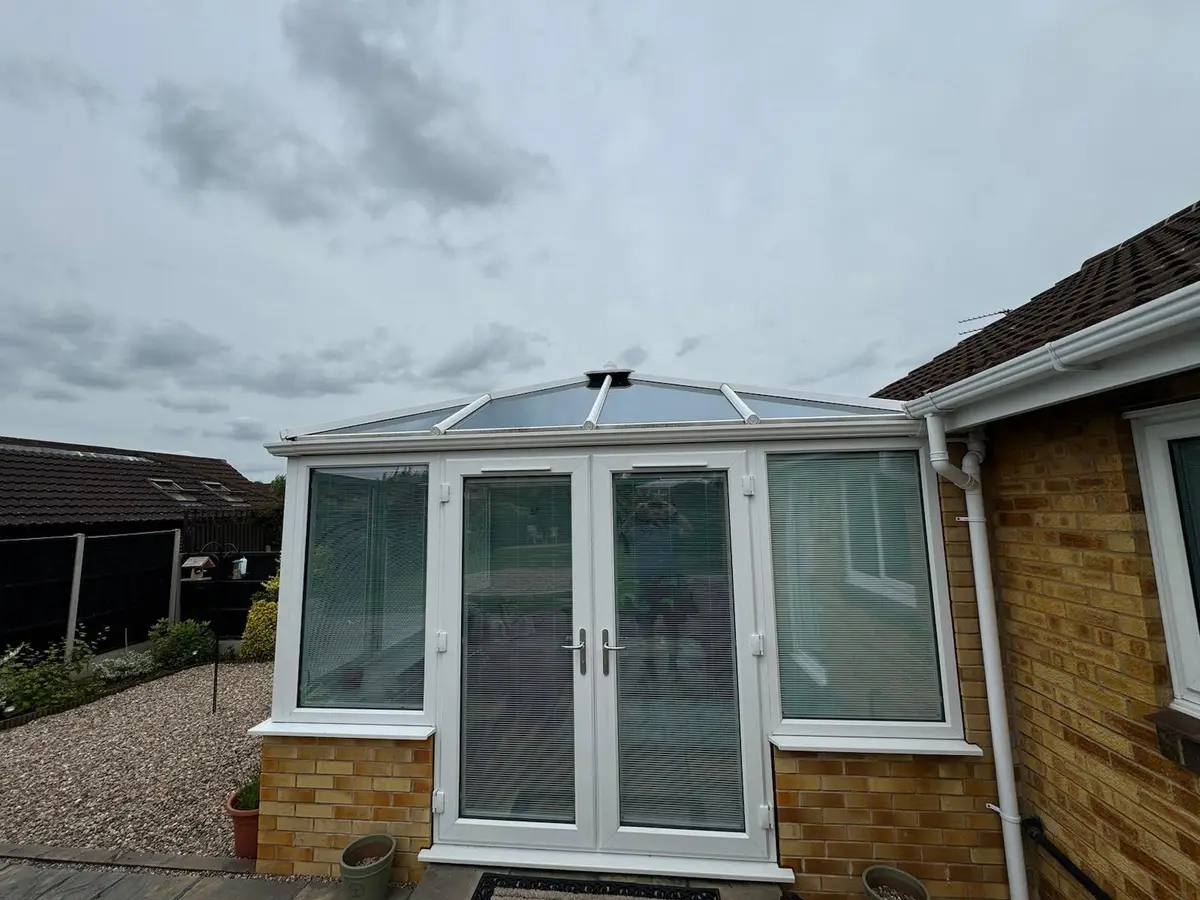 Bungalow rear with a white conservatory now under a new grey insulated roof