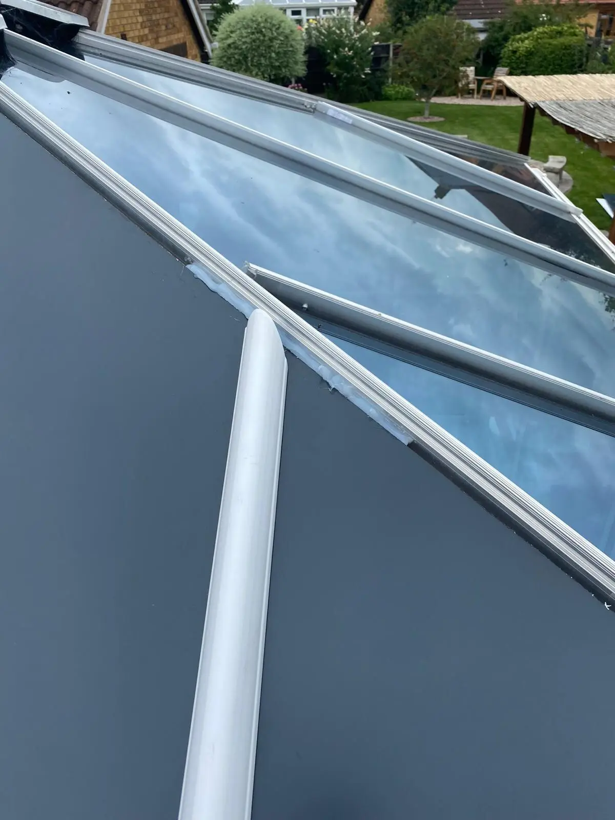 Close view of fresh grey panels beside glass sections awaiting replacement