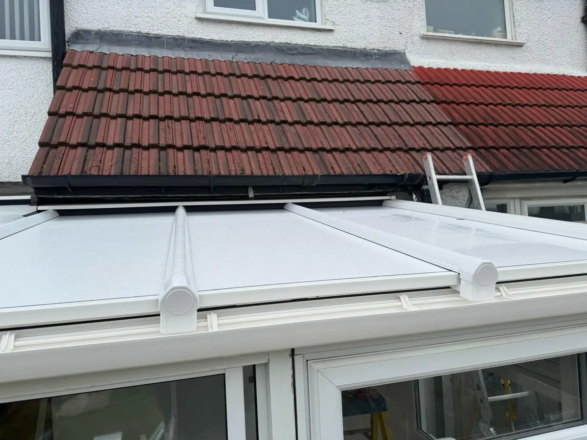 Close view of glazing bar caps and white panels on a completed lean-to roof
