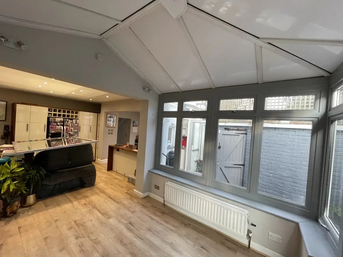 New white panelled ceiling in a conservatory that leads through into the kitchen and dining space