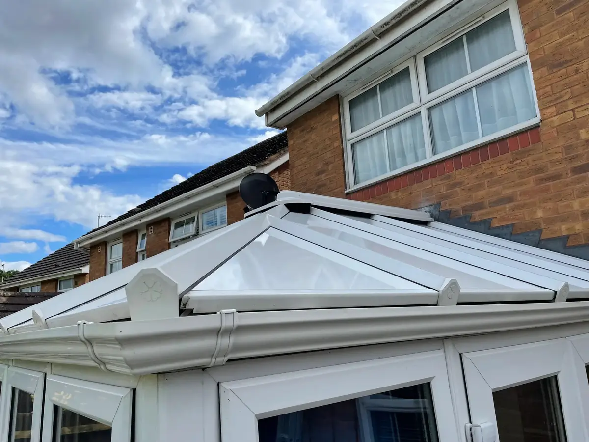 Close view of fresh guttering, end caps on the glazing bars and white insulated panels on a conservatory