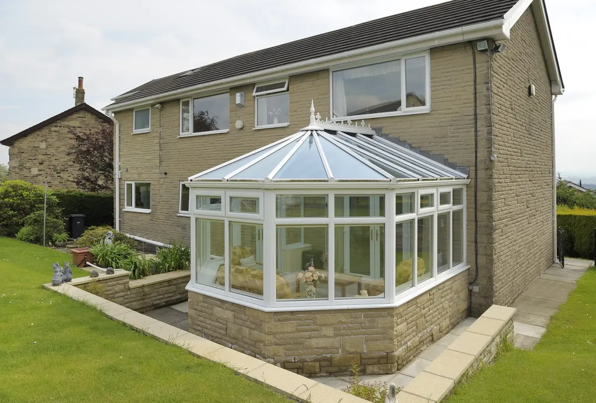 Stone-built house with a Victorian conservatory on its side under a glass roof