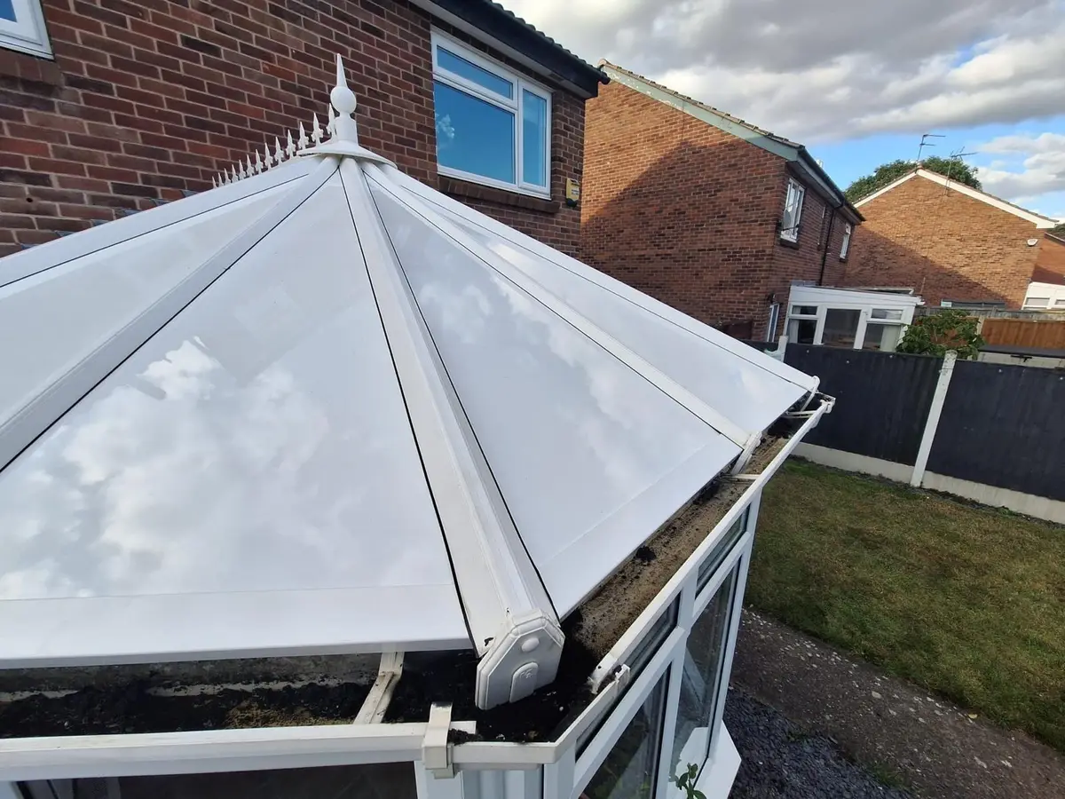 Close view of a finial above glossy white panels on a Victorian conservatory