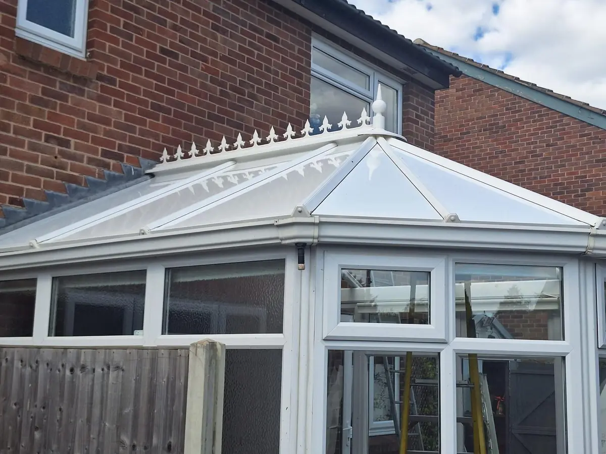 Victorian conservatory topped with ridge cresting over white insulated panels
